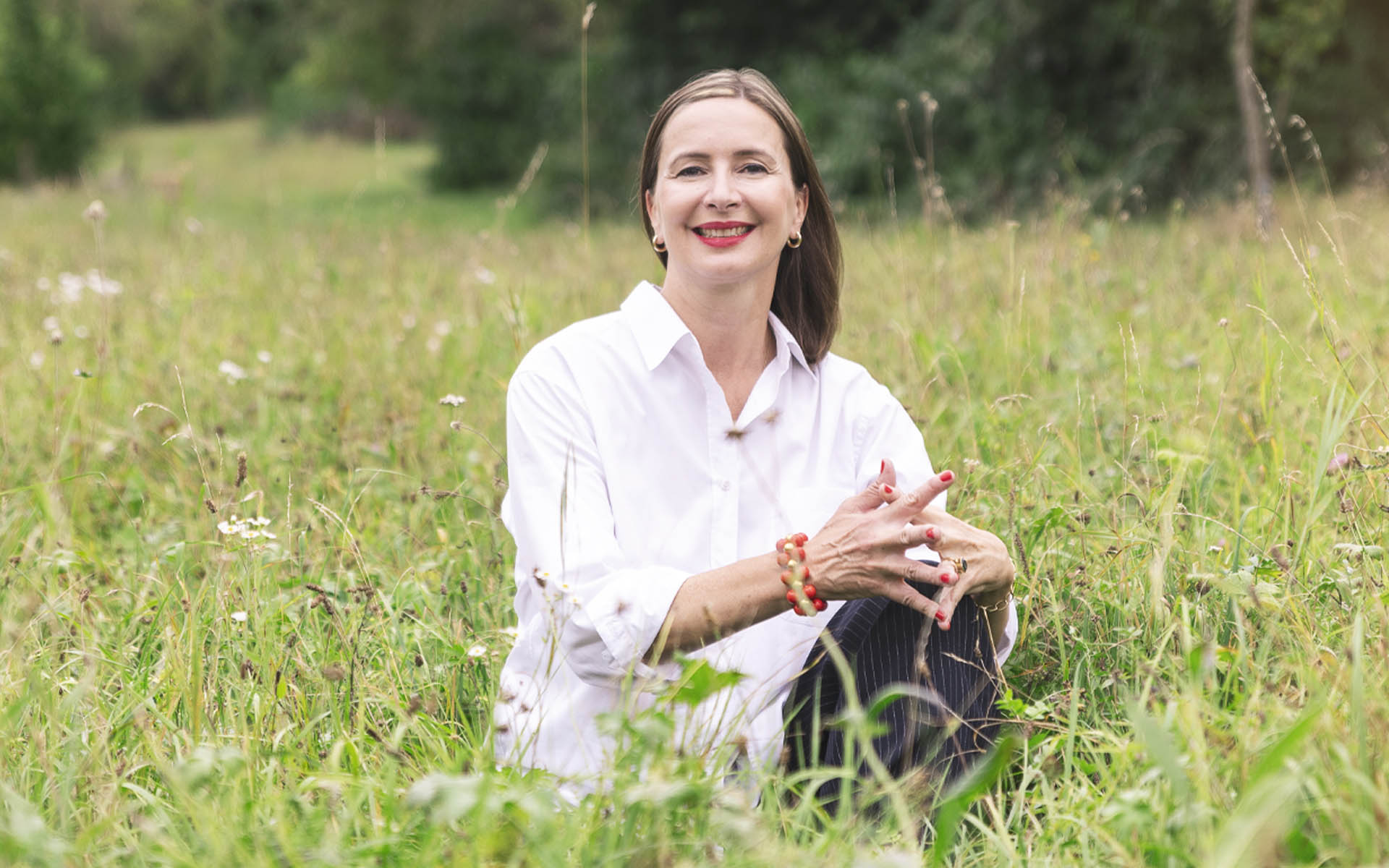 Coachin Kerstin Funcke aus Stuttgart sitzt lächelnd auf einer grünen Wiese – Coaching auf Augenhöhe für Frauen