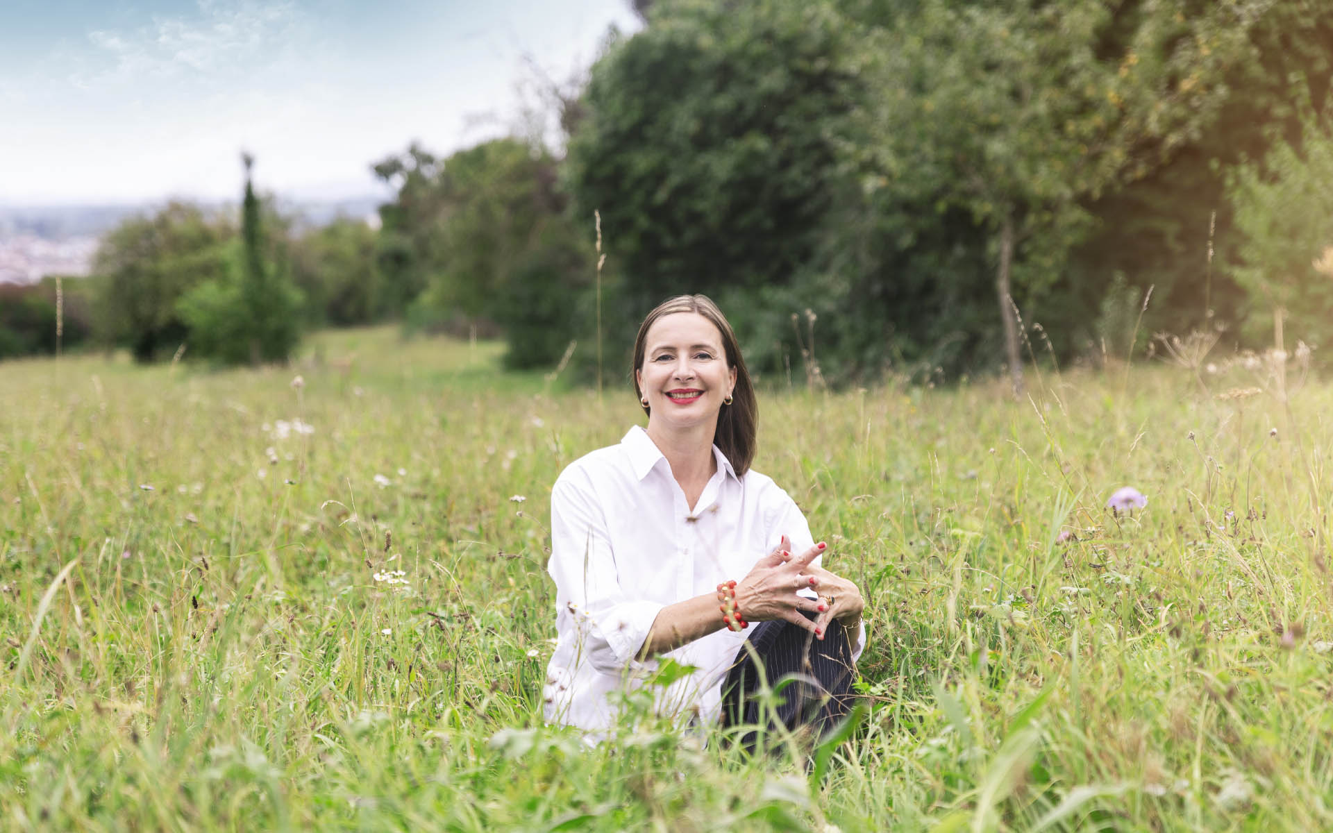 Coachin Kerstin Funcke aus Stuttgart sitzt lächelnd auf einer grünen Wiese – Coaching auf Augenhöhe für Frauen